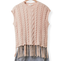 A sleeveless cable-knit sweater vest in a soft dusty pink color, featuring a crew neck and a fringed hem, displayed on a wooden hanger with blue jeans underneath against a white background.