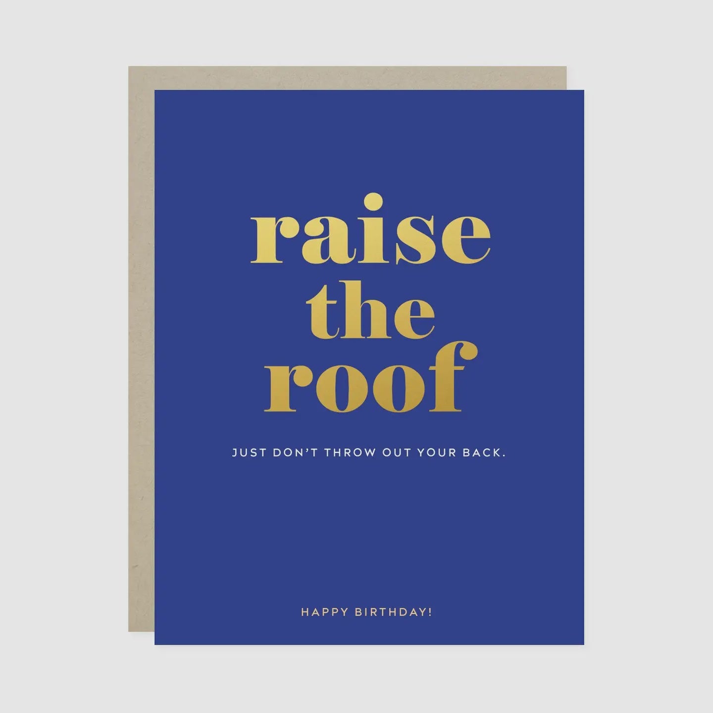 A blue birthday card with gold and white text reading 'raise the roof' and 'HAPPY BIRTHDAY!', shown with a beige envelope behind it on a light gray background.