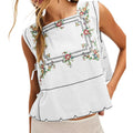 White sleeveless top with floral embroidery on a white background