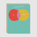 A square greeting card with a Venn diagram design on a teal grid background. One circle is red and labeled 'ME', the other is yellow and labeled 'you', and the overlapping pink-purple intersection is labeled 'SHENANIGANS' with an arrow pointing to it.